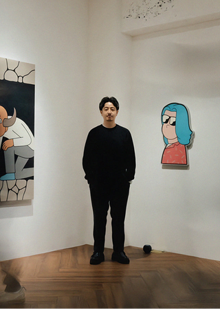 Man standing in an art gallery with artworks on the walls